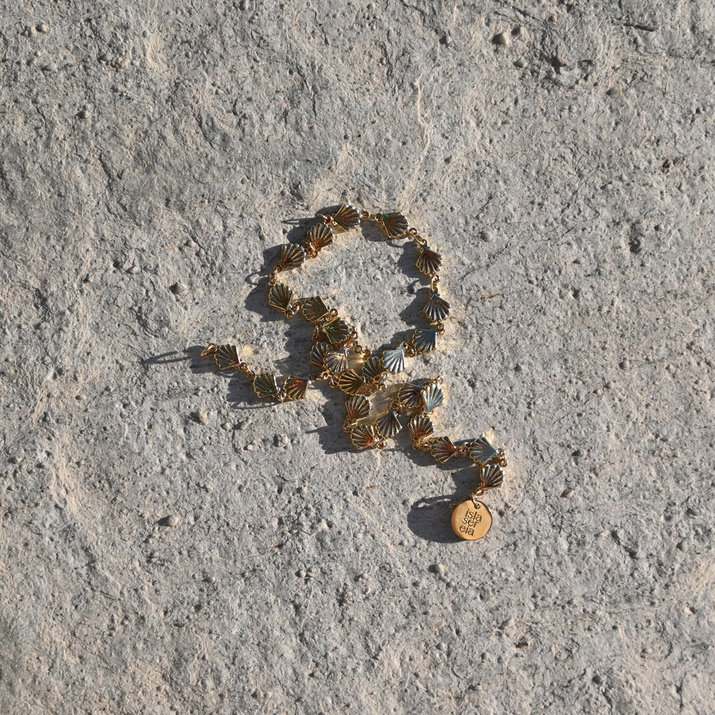 Gold necklace on a textured stone surface