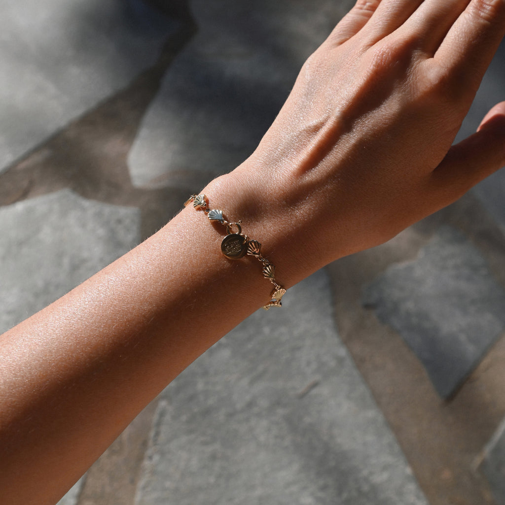Close-up of a hand wearing a bracelet with a stone on a blurred background