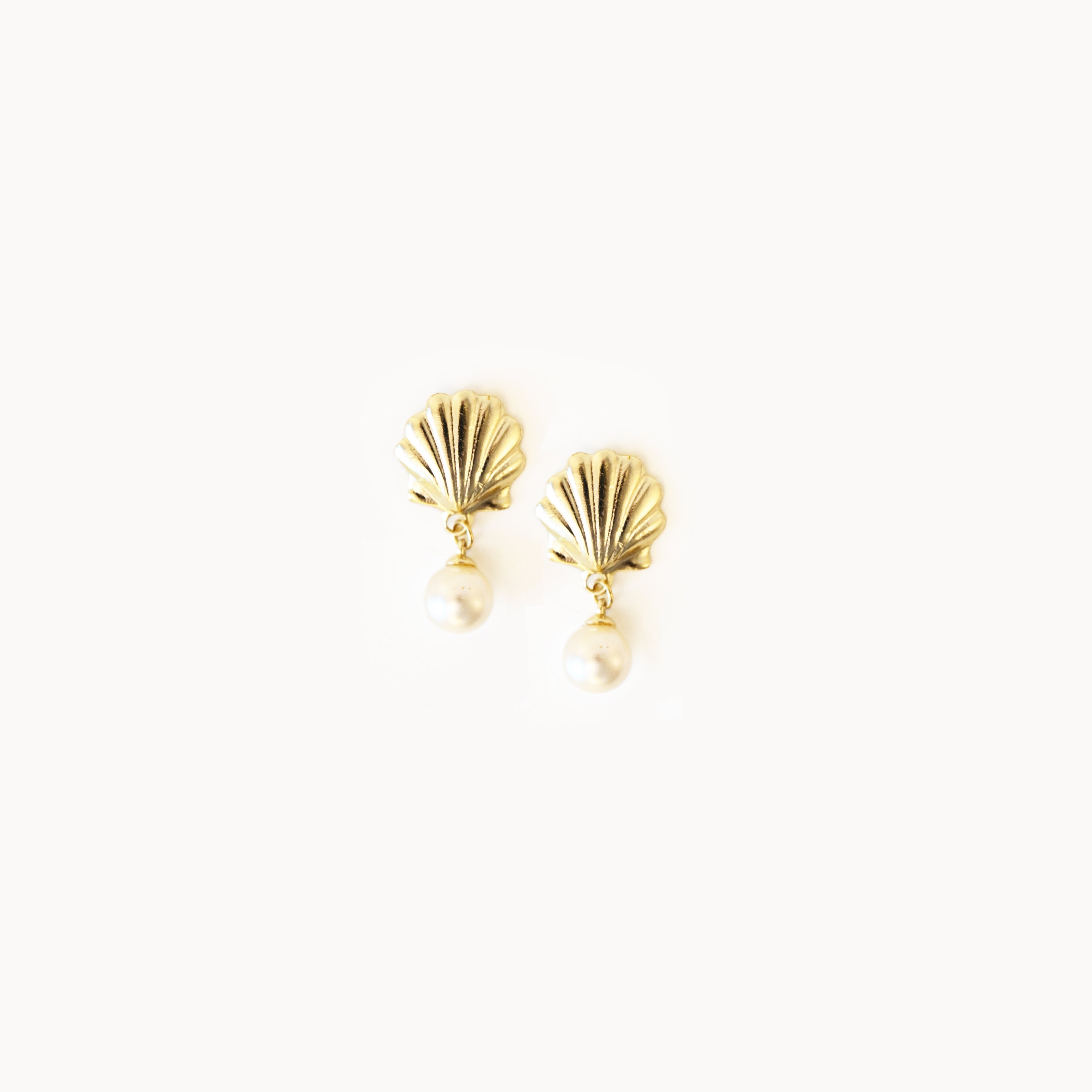 Gold shell-shaped earrings on a white background
